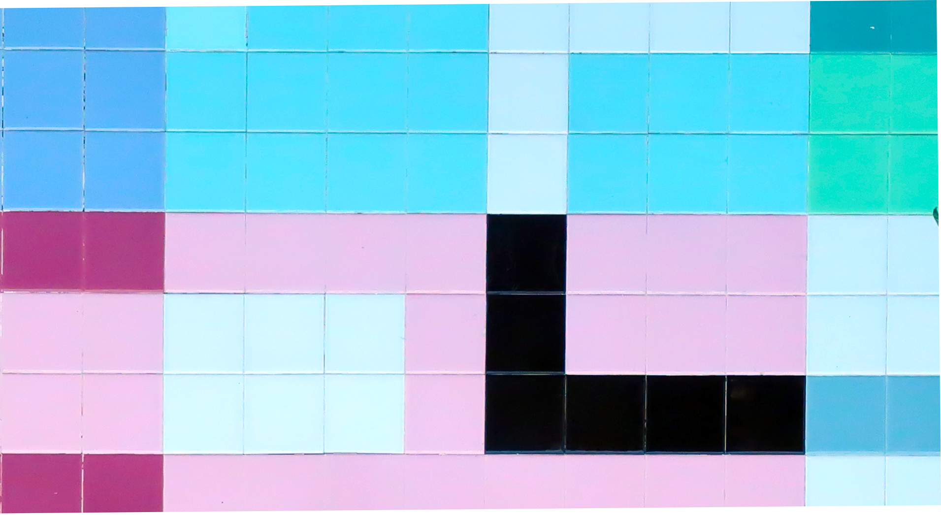 A imagem mostra um padrão de azulejos coloridos organizados de forma geométrica. As cores predominantes são azul claro, rosa, preto, verde e branco, dispostas em blocos retangulares e quadrados que formam um design abstrato e moderno.